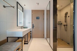 Un baño moderno con un espejo grande, un lavabo y una zona de ducha.