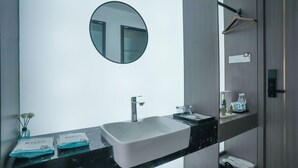 A modern bathroom with a white sink, a round mirror, and a towel rack. - Time Wharf Hotel - Jiefangbei Shibati (Chongqing)