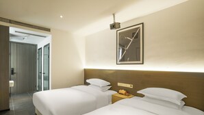 A hotel room with two beds, a nightstand, a projector mounted on the wall, and a door leading to a bathroom. - Time Wharf Hotel - Jiefangbei Shibati (Chongqing)