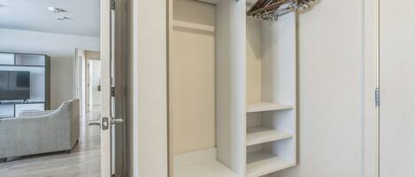 Un closet amplio con repisas abiertas y barra para colgar ropa.