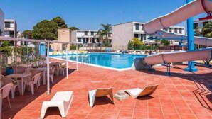 A pool area with a slide, lounge chairs, and a covered seating area. - Reysol Home (Costa Saracena - Castelluccio)