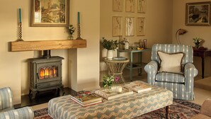 Una sala de estar acogedora con chimenea, muebles con diseños y obras de arte en las paredes.