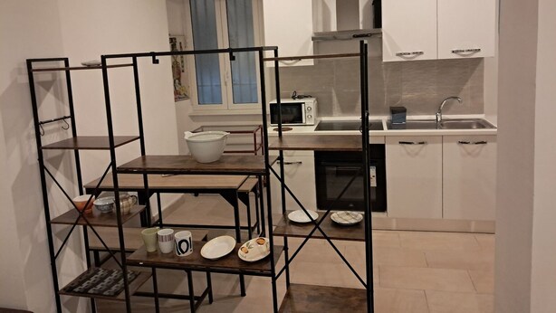 Eine moderne Küche mit weißen Schränken, einer eingebauten Mikrowelle und einem Spülbecken.