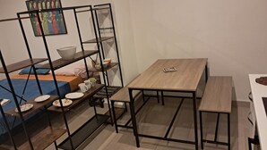 Ein schmaler Raum mit einer Etagenbett, einem kleinen Tisch und einer Bank.