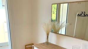 A modern bathroom with a wooden vanity, a mirror, and a vase with dried flowers. - NEW! 2 Bedrooms, 2 Bathrooms, Free Car Box 100m from the sea (Alba Adriatica)