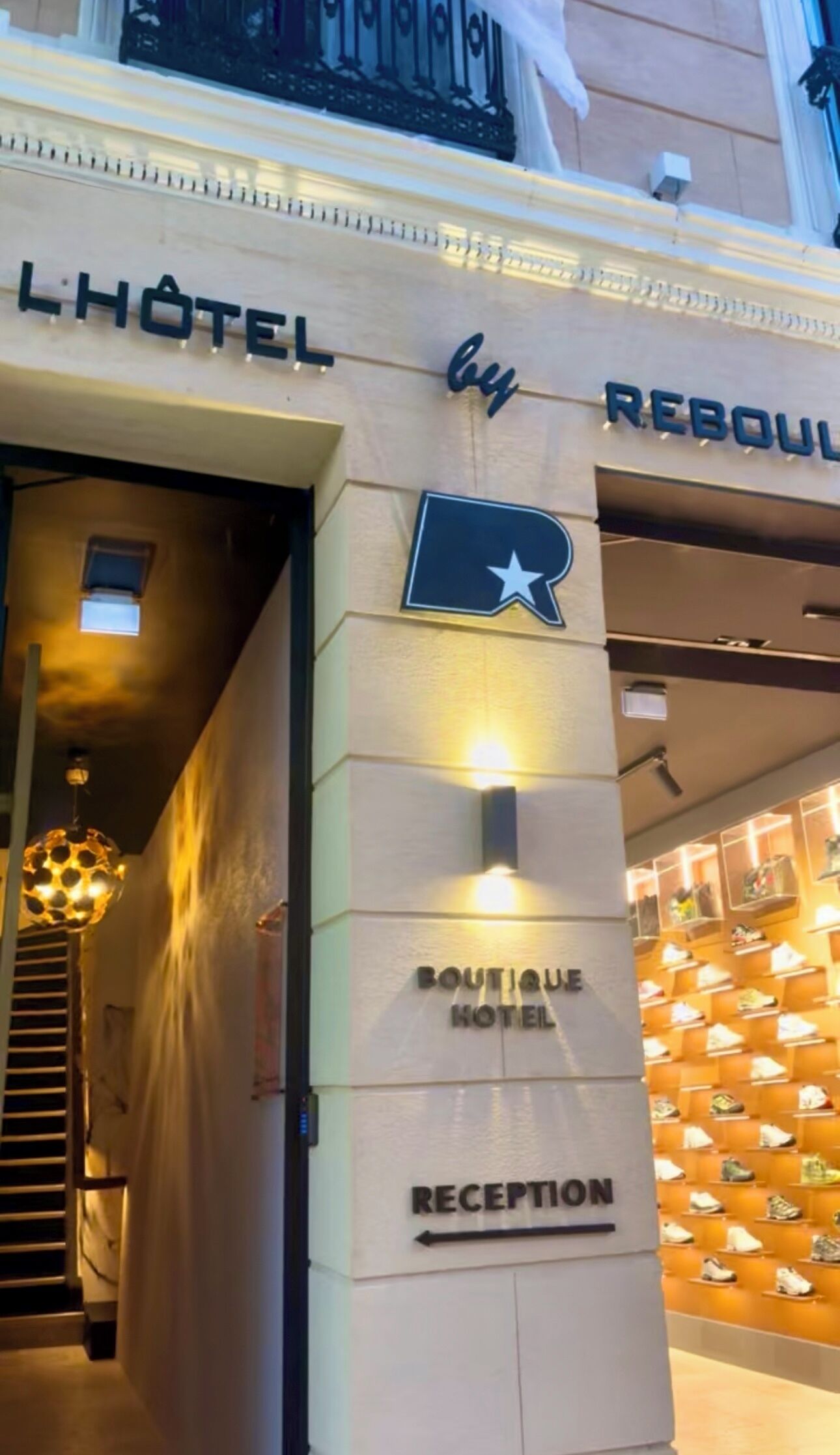 The entrance to a boutique hotel with a reception area and a shoe display.