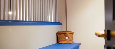 A blue desk with a scale, a brown bag, and a door handle.