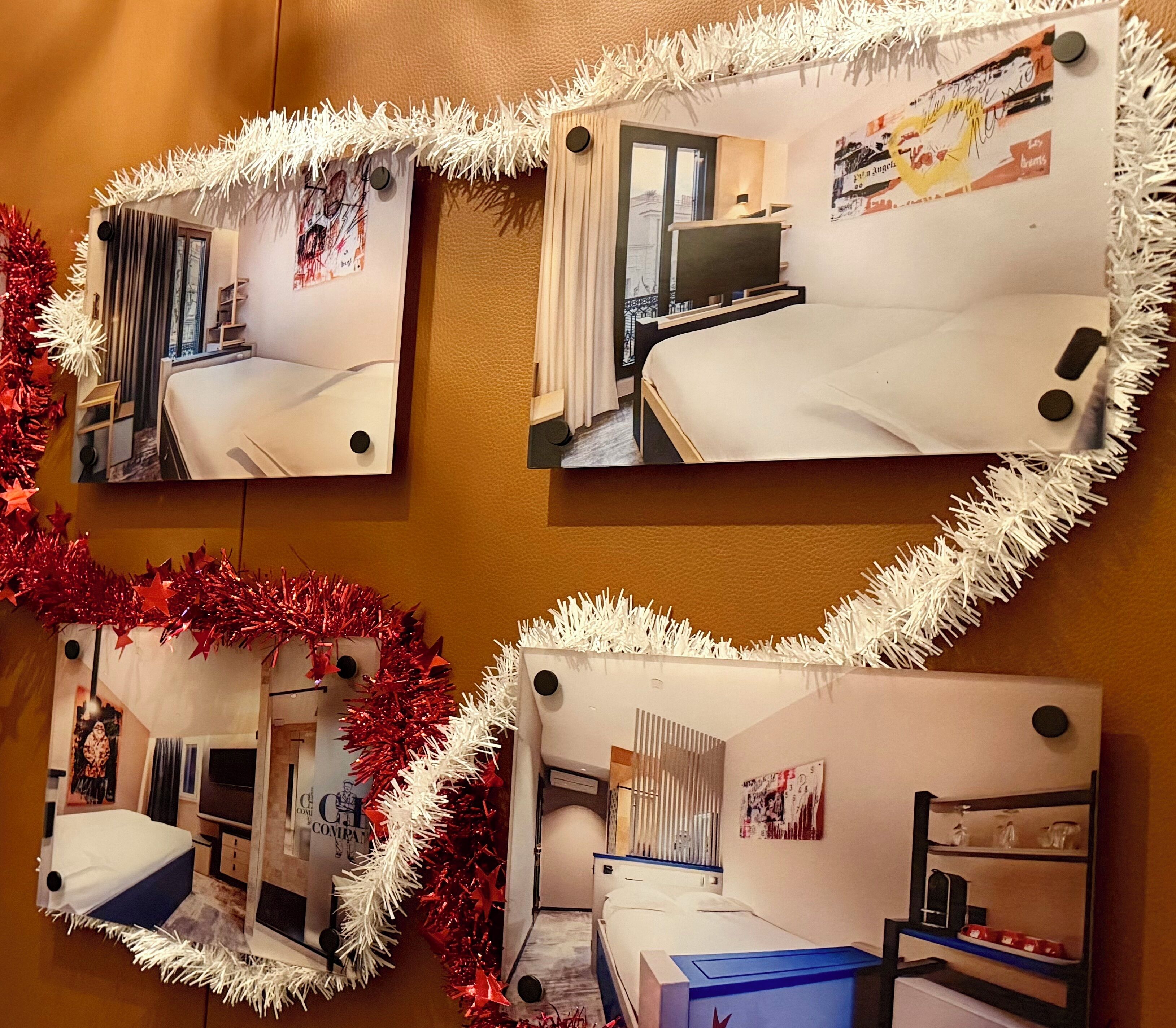 A hotel room with a bed, a desk, and a chair. There is a window with curtains, a wall-mounted TV, and a calendar.