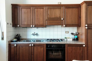 Exclusief appartement, balkon, uitzicht op de stad | Privékeuken | Een koelkast, een oven, een kookplaat, kookgerei, borden en bestek