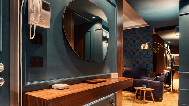 A modern bathroom with a wooden vanity, a mirror, a white telephone, and a small round table with a blue object on it. - Modern apt near the Centre (Milan)