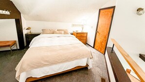 A neatly arranged bedroom with a bed, bedside table, lamp, and a bench. - Treetop Village Sunset Hollow #105-3BD/3BA/Pools/Grill/Dock/Deck-6PP (Village of Four Seasons)