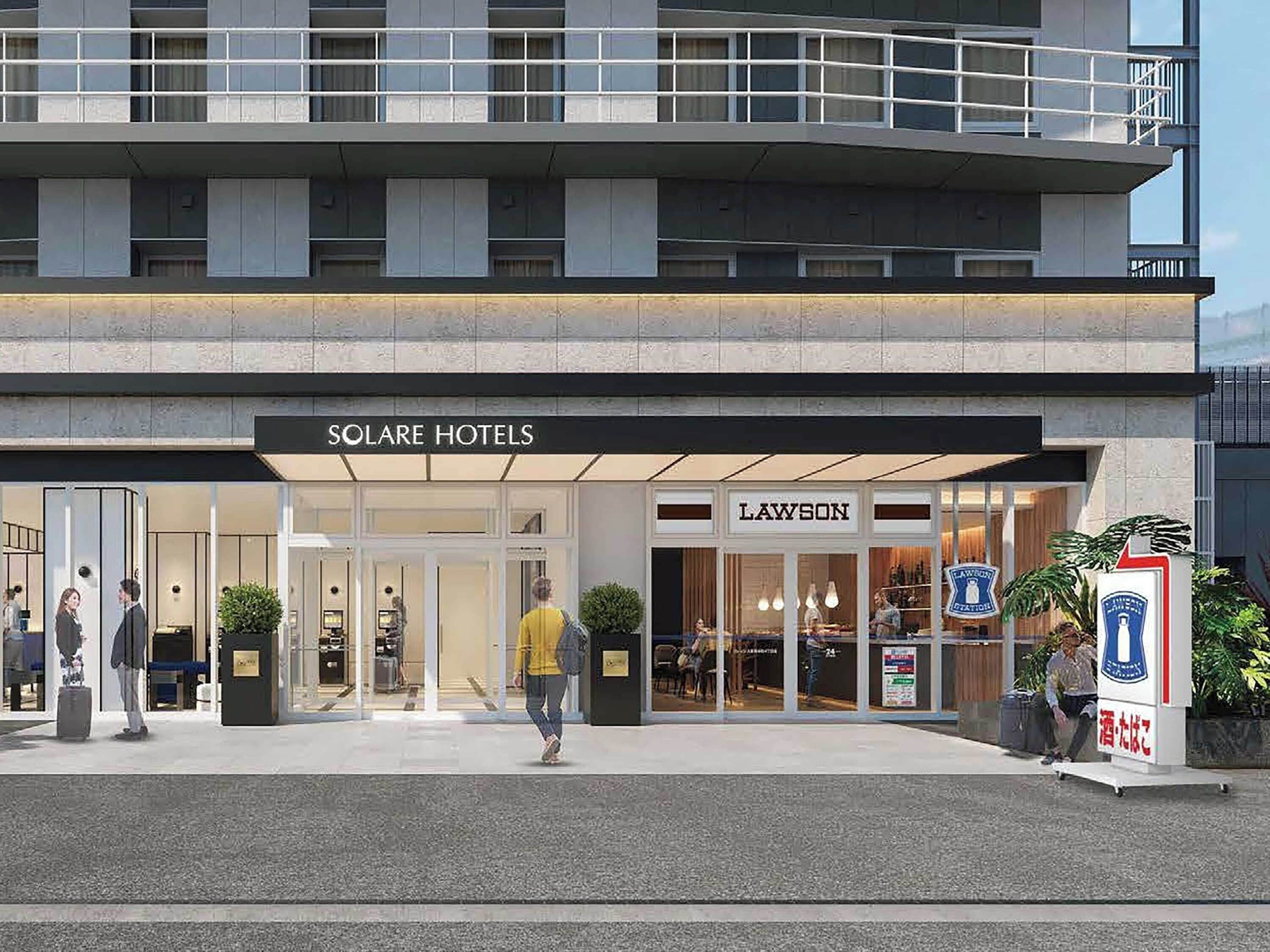 Un hotel con fachada moderna, que presenta una entrada destacada con puertas de vidrio y un cartel que dice "SOLARE HOTELS".