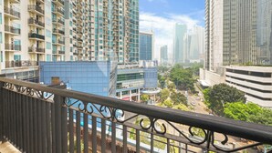 A high-rise building with multiple balconies and a modern glass facade. - Marmo by Kozystay - Kuningan (Jakarta)