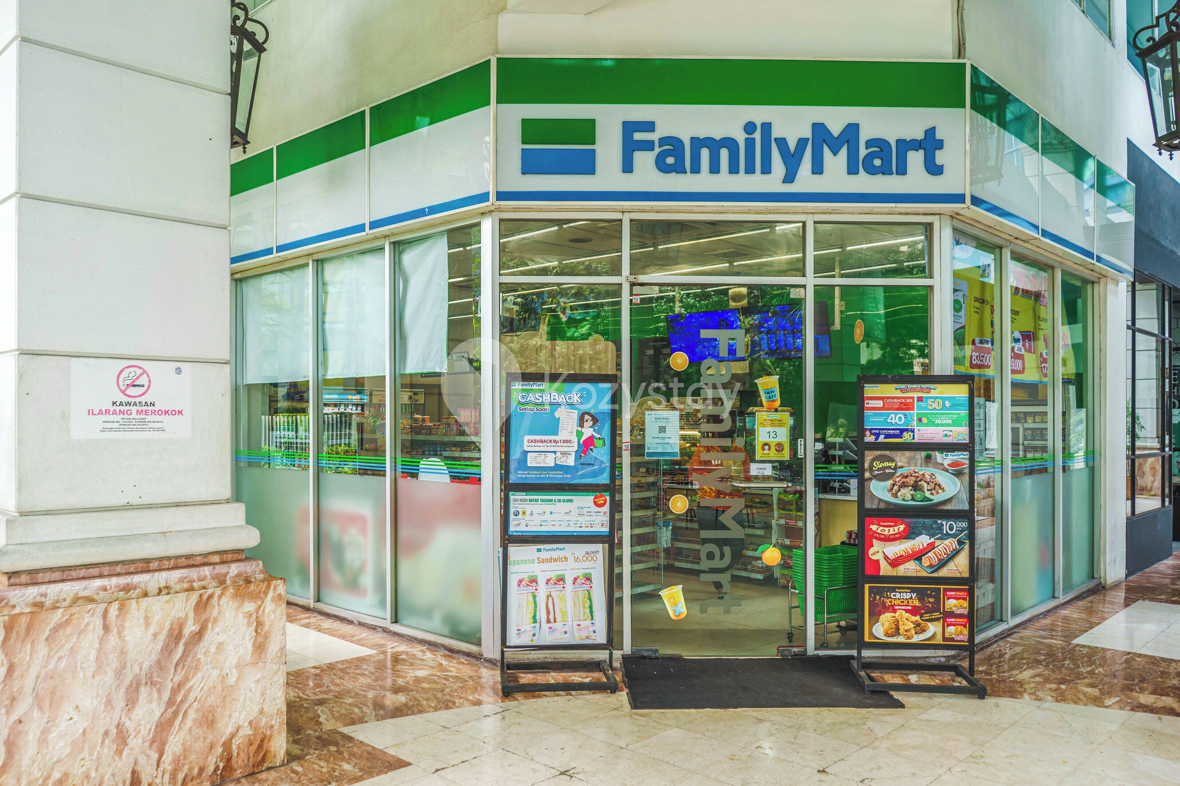 A FamilyMart store with a clear entrance, glass windows, and promotional signs.