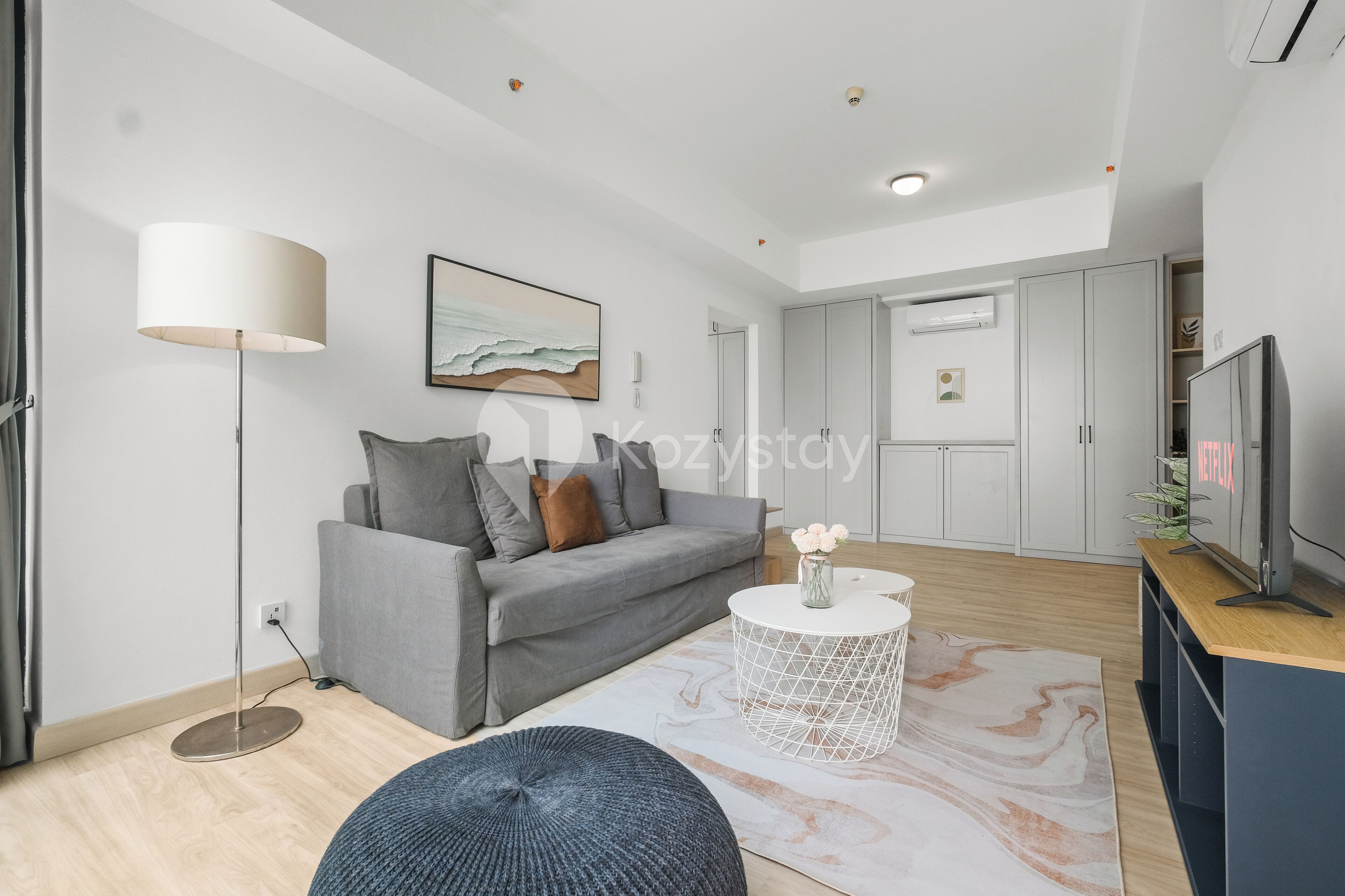 A modern living room with a grey sofa, a round coffee table, and a floor lamp.