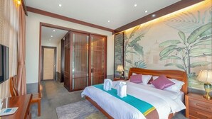 A hotel room with a bed, bedside tables, a TV, a desk, and a wardrobe.