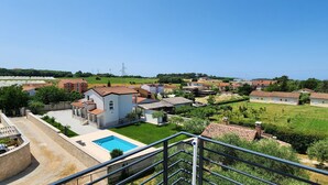 A residential area with houses, a swimming pool, and a clear sky.