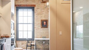 A modern kitchen with a wooden ceiling, a large window, and a stone backsplash. - Bradshaw Lofts: The Tapestry (Stratford)