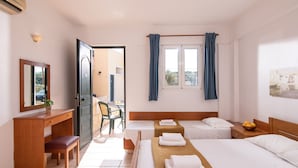 A hotel room with two beds, a desk, a chair, and a window with curtains.