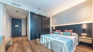 Une chambre d’hôtel moderne avec un grand lit, un bureau et une armoire.