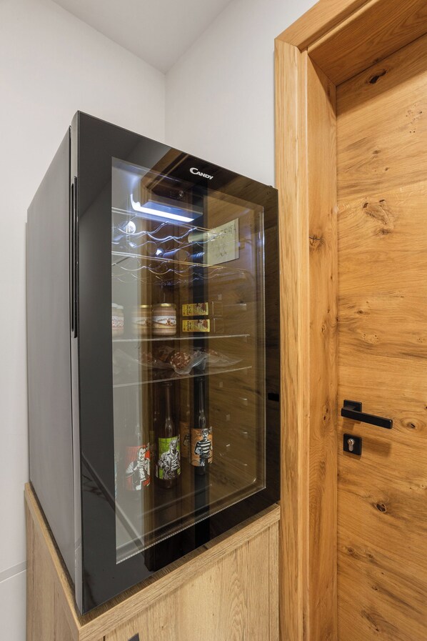 A black refrigerator with a glass door, containing various food items and beverages.