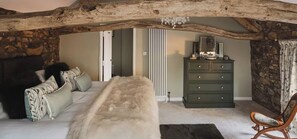 Un dormitorio con una cama grande, un aparador y una silla.