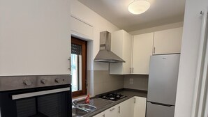 A modern kitchen with white cabinets, a stainless steel range, a built-in oven, a gas stove, and a refrigerator. - Oasi Perugina - maximum comfort in the beating heart of Perugia (Perugia)