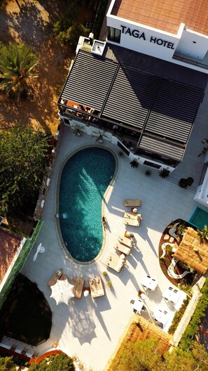 Vista aérea de un hotel con piscina, zona de estar y asientos al aire libre.