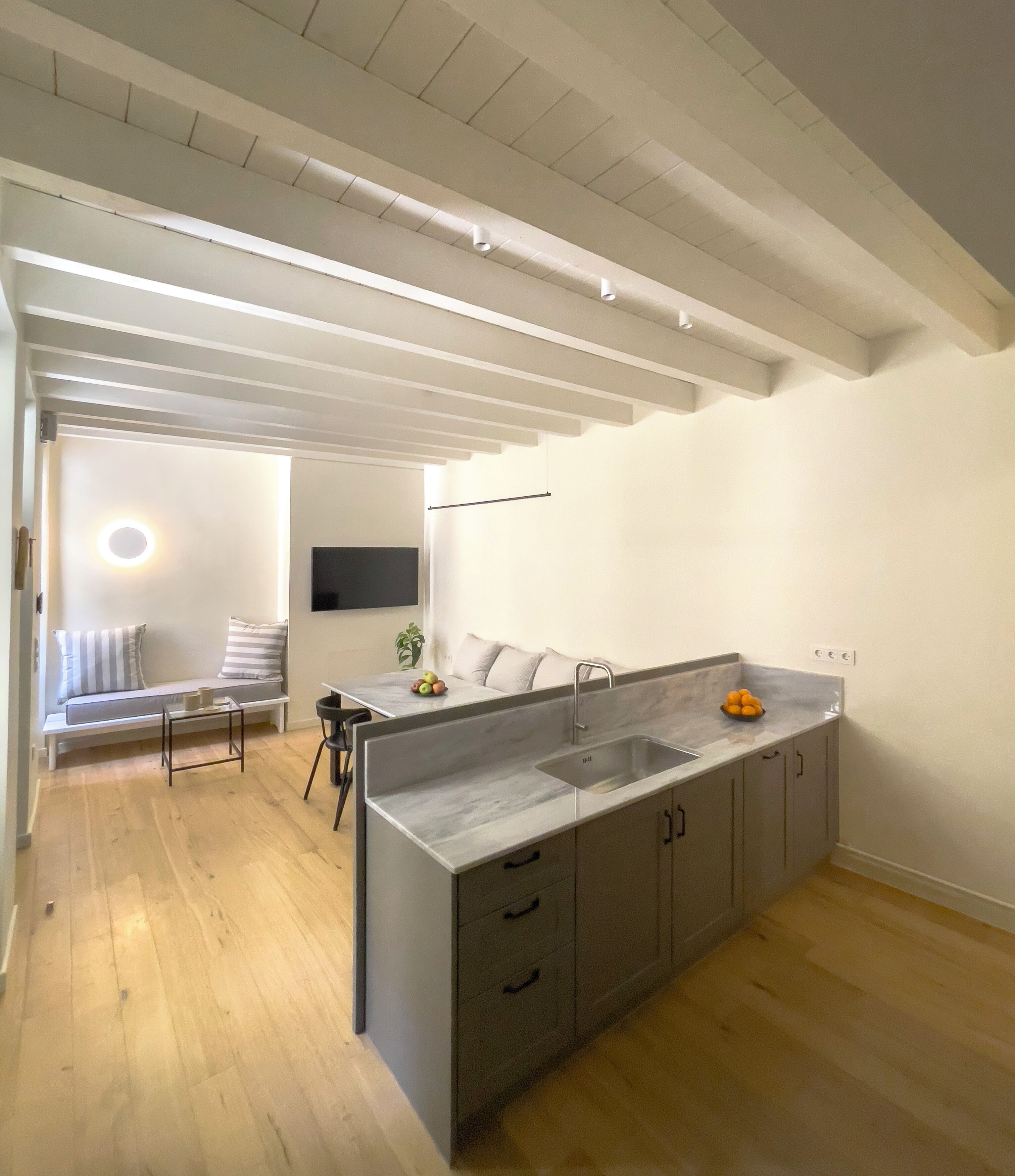 Una cocina moderna con una isla grande, suelo de madera y un diseño minimalista.