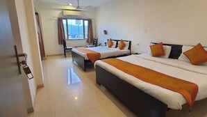 A hotel room with two beds, a desk, and a chair. - Hotel Shree Vilas (Nathdwara)