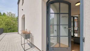 A modern building entrance with a glass door labeled "APT2".