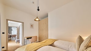 A bedroom with a bed, a desk, and a chair.
