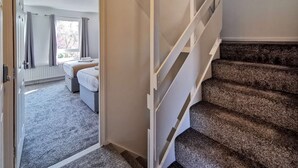 Une chambre d’hôtel avec un lit, une salle de bain et un escalier.