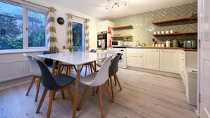 Une cuisine moderne avec une table à manger, des chaises et divers appareils électroménagers.