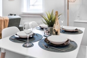 A dining table set with plates, cutlery, and a bottle of champagne. - 30 Monthly Discount Long-stay St Mary s Nest (Huntingdon)