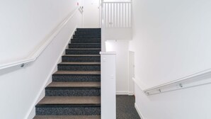 A staircase with carpeted steps leading to a white door.