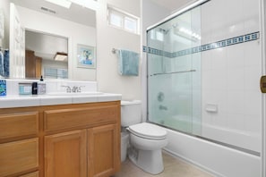 A modern bathroom with a wooden vanity, white toilet, glass shower enclosure, and a tiled shower area. - Capitola Sea Winds one block to Capitola Beach (Capitola)