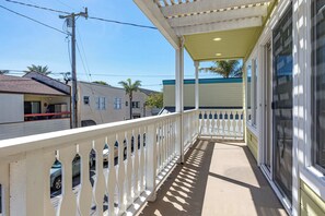 A covered balcony with a white railing, a concrete floor, and a view of adjacent buildings. - Capitola Sea Winds one block to Capitola Beach (Capitola)