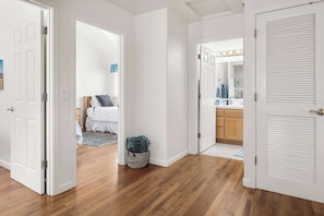 A hallway with wooden flooring, white walls, and open doors leading to a bedroom and a bathroom. - Capitola Sea Winds one block to Capitola Beach (Capitola)