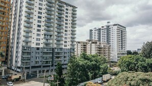 Un edificio residencial de varios pisos con balcones, zona de estacionamiento y vegetación circundante.