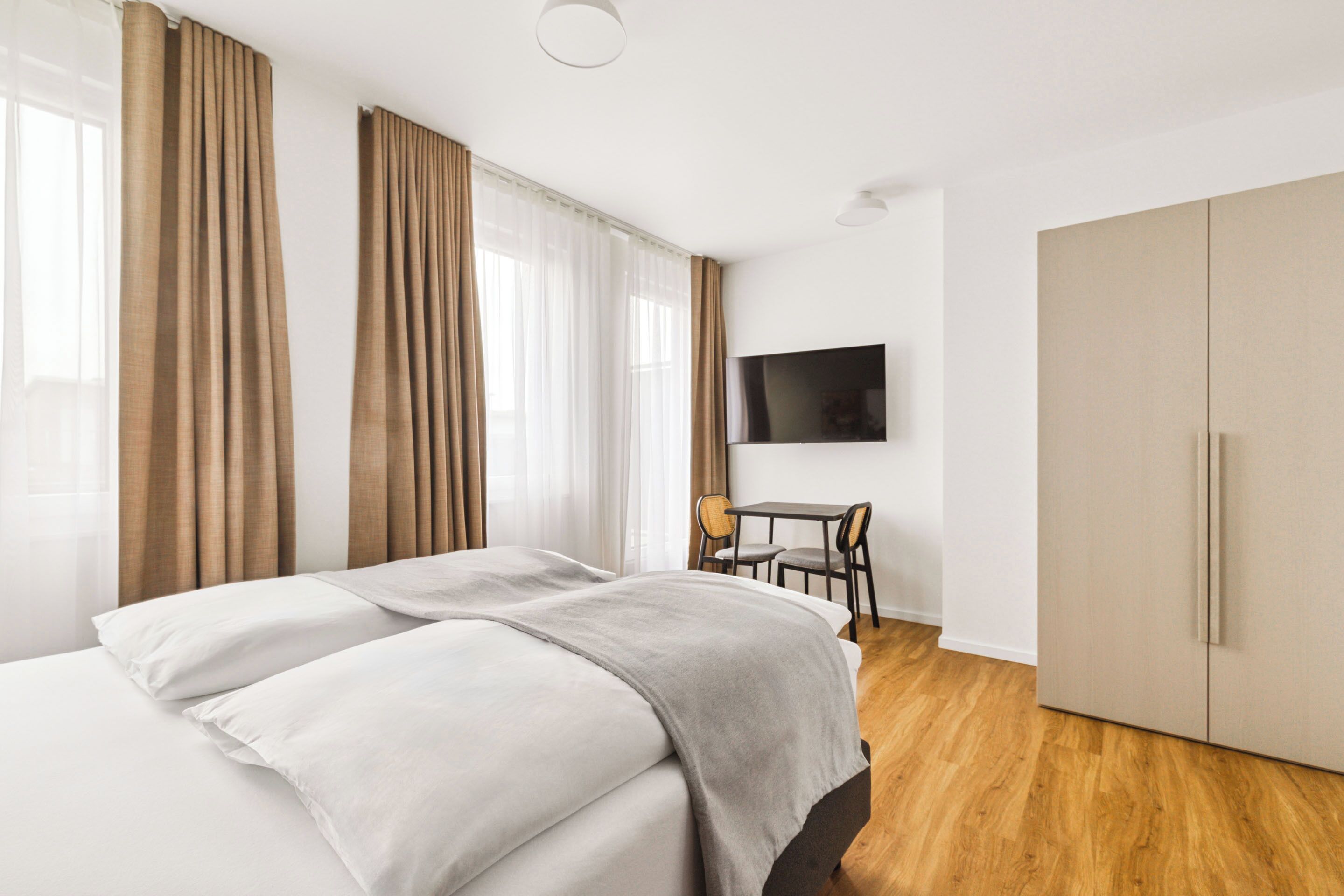 Un dormitorio con cama, escritorio, silla y armario.