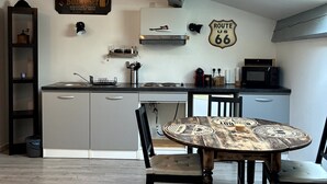 A modern kitchen with a central island, a dining table with chairs, and a ceiling fan. - Cosy and relaxing atmosphere in St Zacharie, in the heart of the village. (Unknown)