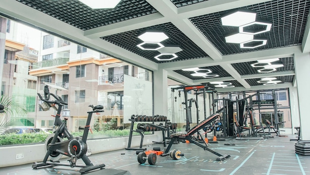 A gym with exercise equipment, including treadmills, dumbbells, and weight machines. - The Snug Haven (Nairobi)