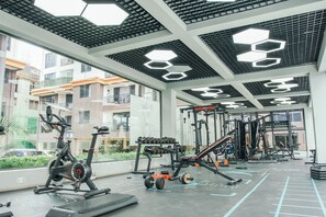 A gym with exercise equipment, including treadmills, dumbbells, and weight machines. - The Snug Haven (Nairobi)