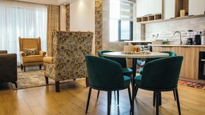 A modern living room with a round table and four chairs, a sofa, and a decorative partition. - The Snug Haven (Nairobi)