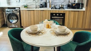 A dining table set with plates, bowls, glasses, and a toaster. - The Snug Haven (Nairobi)