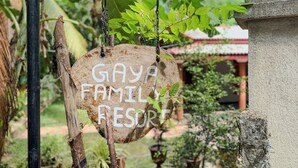 Un letrero con la leyenda 'GAYA FAMILY RESORT' colgado de un poste de madera.