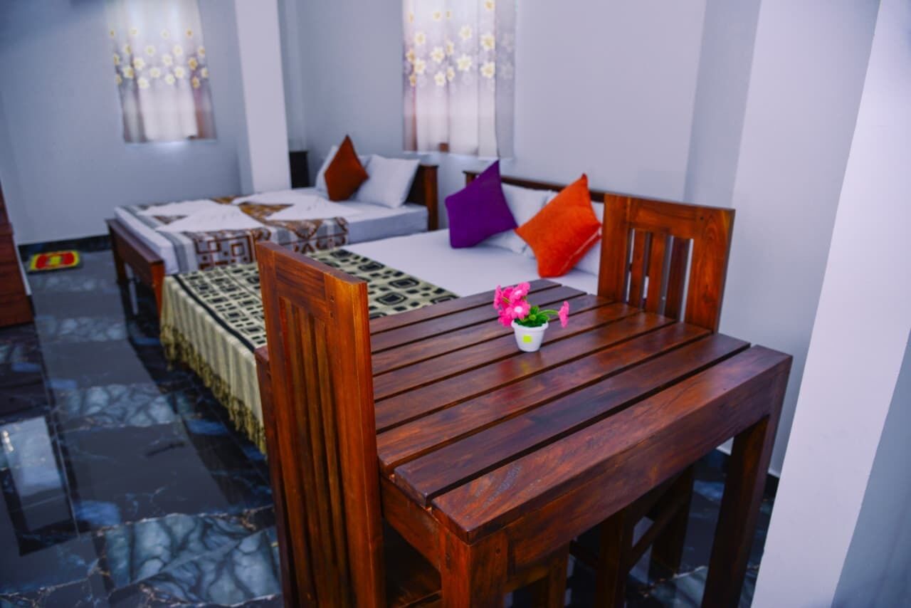 Una habitación con una cama, una mesa de madera y una pequeña planta en maceta.