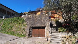 A stone building with a wooden door, a staircase, and a small garden area. - .\tGreen in the city exists: discover it at the Hedgehog Mansion with your furry..... (Bergamo)