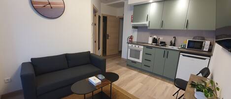 A modern apartment with a living room, kitchenette, and a dining area.